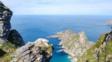 Bleik, Andoya, Norveç 'teki Matind Dağı' nın nefes kesici manzarası. Görkemli uçurumlar canlı mavi okyanustan dramatik bir şekilde yükseliyor, dingin ve pitoresk bir doğal çekilme sunuyor..