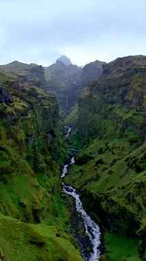 İzlanda 'daki görkemli Mulagljufur Kanyonu' nu keşfedin. Orada yemyeşil kayalıklar dolambaçlı bir nehri kucaklıyor. Bu nefes kesen yerin doğal güzelliğini ve huzurunu hissedin..