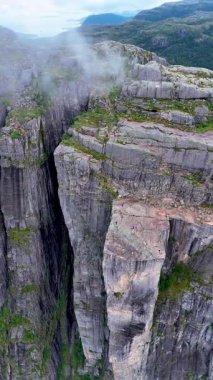 Norveç 'te, maceraperest yürüyüşçülerin Lysefjord' un üzerindeki panoramik manzaralardan hoşlandıkları göz kamaştırıcı manzaraları deneyimleyin. Sis sarar kayalık kayalıkları, gizemli bir atmosfer yaratır..