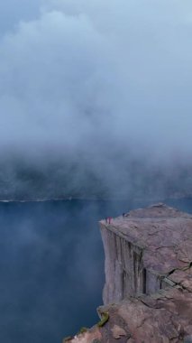 Norveç 'te, maceraperest yürüyüşçülerin Lysefjord' un üzerindeki panoramik manzaralardan hoşlandıkları göz kamaştırıcı manzaraları deneyimleyin. Sis sarar kayalık kayalıkları, gizemli bir atmosfer yaratır..