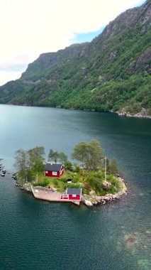 Huzurlu bir adada yuva yapmış büyüleyici kırmızı kulübeleriyle Norveç 'in güzelliğini hissedin..