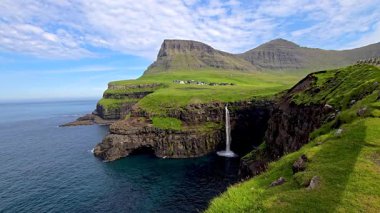 Mullafossur şelalesi Atlantik Okyanusu 'na güzel bir şekilde düşer. Etrafı yemyeşil uçurumlar ve Faroe Adaları' nın engebeli dağlık arazileriyle çevrilidir.