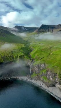 Skardsafossur şelalesi, büyüleyici Faroe Adaları 'ndaki yemyeşil tepeler ve dramatik uçurumlarla çevrili sakin denize akar..