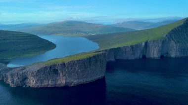 Derin mavi sulardan yükselen yüksek uçurumlarla Faroe Adaları 'nın nefes kesici güzelliğini deneyimleyin. Bereketli yeşil yamaçlar huzurlu Sorvagsvatn Gölü 'nü tamamlar, Vagar.