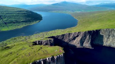 Faroe Adaları 'nın nefes kesici uçurumlarını ve sakin sularını tecrübe edin. Bereketli yeşillik engebeli manzarayı, güzelliği ve sükuneti gözler önüne seriyor. Sorvagsvatn Gölü, Vagar