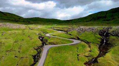 Faroe Adaları 'nın nefes kesen güzelliğini, kıvrımlı, yeşil tepelerin arasında dolambaçlı bir yol olarak tecrübe edin..