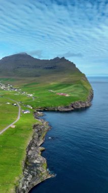 Faroe Adaları 'nın turkuaz sularının üzerinde çarpıcı uçurumlar yükselir. Verimli yeşil tepeler ve tuhaf köyler karayla deniz arasındaki uyumu gösteren pitoresk bir manzara yaratıyor..