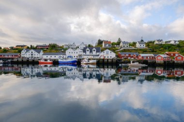 15 Ağustos 2025 'te bir Lofoten Norveç' i, antika balıkçı tekneleri fiyortun sakin sularında usulca yüzer. Üzerimizde bulutlar sürüklenirken renkli evler güzel bir şekilde yansıyor.