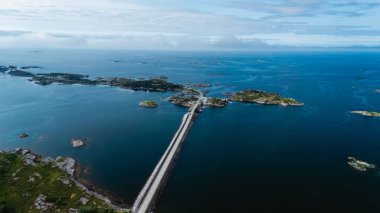 Norveç 'teki Atlantik Okyanusu Yolu' nu gösteren nefes kesici hava manzarası manzaralı adaları birbirine bağlayan benzersiz köprülerini sunuyor. Canlı mavi sular gökyüzünü yansıtıyor ve sakin bir atmosfer yaratıyor..