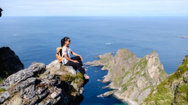 Matind Dağı 'nın kıyısında oturan bir yürüyüşçü Bleik ve Atlantik Okyanusu' nun çarpıcı kıyı manzarasının tadını çıkarıyor. Berrak gökyüzü ve sakin sular macera ve sükunet için mükemmel bir zemin oluşturur..