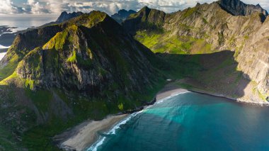 Görkemli dağlar Norveç 'in Lofoten kentindeki Ryten Kvalvika Patikası boyunca el değmemiş bir sahil oluşturur..
