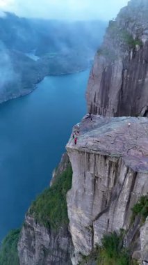 Norveç 'te, maceraperest yürüyüşçülerin Lysefjord' un üzerindeki panoramik manzaralardan hoşlandıkları göz kamaştırıcı manzaraları deneyimleyin. Sis sarar kayalık kayalıkları, gizemli bir atmosfer yaratır..