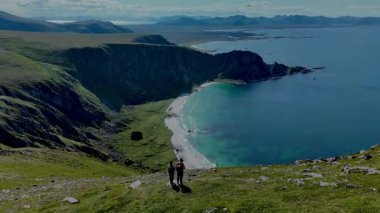 Norveç 'in Matind Andoy kentindeki çarpıcı sahil tepelerinde gezinen tanık yürüyüşçüleri. Yeşillik dramatik kayalıklarla buluşur ve açık hava macerası için mükemmel bir zemin oluşturur..