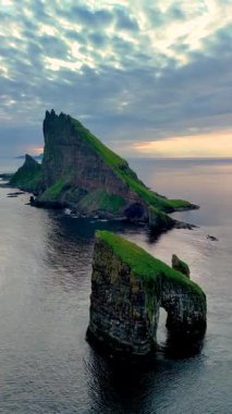 Alacakaranlık sırasında Faroe Adaları 'ndaki Drangarnir Kayalıkları' nın nefes kesici kıyı manzarası. Engebeli uçurumlar Atlantik 'ten dramatik bir şekilde yükseliyor, doğal güzellikleri ve huzuru gözler önüne seriyor..
