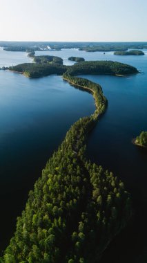 Finlandiya 'daki Punkaharju' nun nefes kesici güzelliğini keşfedin, yemyeşil ağaçlar sakin mavi sularla çevrili eşsiz bir esker yolu üzerindedir. Doğa aşıkları için mükemmel bir yer..