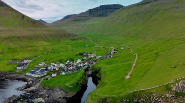 Faroe Adaları 'ndaki yemyeşil tepeler ve dramatik uçurumlar arasında yuva yapmış küçük bir köy olan Gjogv' un nefes kesici güzelliğini görün..
