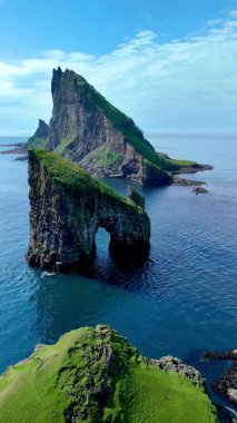 Görkemli Drangarnir uçurumları yemyeşil sulardan yükselirken Faroe Adaları 'nın çarpıcı güzelliğini yakalayın. Bu uzak cennetin sakinliğini hisset..