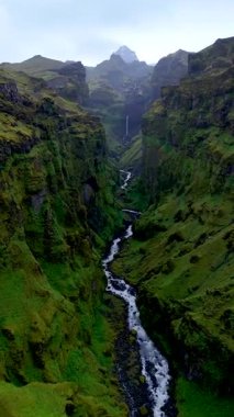İzlanda 'daki Mulagljufur Kanyonu' nun nefes kesici manzaralarını keşfedin, kıvrımlı bir nehrin yeşil uçurumlardan aktığı. Görkemli şelaleler ve çarpıcı yeşillikler huzurlu bir kaçış yaratır..