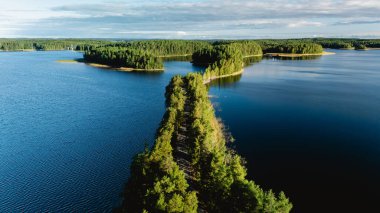 Finlandiya, Punkaharju 'nun nefes kesen manzarasını keşfedin. Huzurlu bir esker yolunun yemyeşil ve sakin göllerde dolaştığı ve doğaya mükemmel bir kaçış sunduğu bir yer..