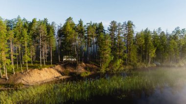 Bir göl, verimli ağaçlar ve sakin sularla çevrili Hossa Ulusal Parkı 'nda sakin bir kaçış sağlar. Finlandiya 'da gün doğumunda bu doğal cennetin huzurlu atmosferini deneyimleyin.