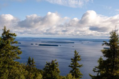 Koli Milli Parkı 'ndan nefes kesici bir manzara, parlak bir gökyüzünün altındaki yeşil ormanların arasına yerleştirilmiş sakin gölleri ortaya çıkarıyor. Huzur ve doğal güzellik arayan açık hava meraklıları için mükemmel..