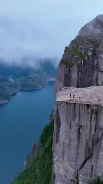Norveç 'te, maceraperest yürüyüşçülerin Lysefjord' un üzerindeki panoramik manzaralardan hoşlandıkları göz kamaştırıcı manzaraları deneyimleyin. Sis sarar kayalık kayalıkları, gizemli bir atmosfer yaratır..