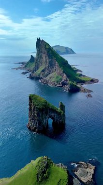 Faroe Adaları 'nın sakin Kuzey Atlantik sularından nefes kesici Drangarnir kayalık oluşumları ortaya çıkar. Yeşillik, çarpıcı uçurumlarla çelişiyor. Resimli bir kıyı manzarası yaratıyor..
