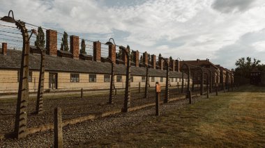 Polonya 'daki Auschwitz Birkenau toplama kampının rahatsız edici görüntüsü. Kışlalar ve dikenli teller, bölgenin kasvetli atmosferini yansıtan tarihin tüyler ürpertici bir anımsatıcısını oluşturuyor..