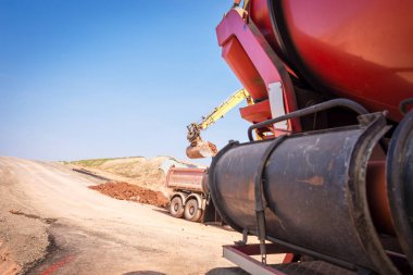 Baggerfhrer ladet Erde auf den Kipper