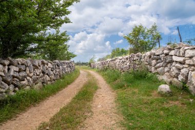 Am Strassenrand ausgelegter Zaun aus Steinen