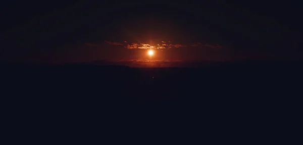 Ηλιοβασίλεμα σε ζεστά χρώματα και κοντά σε κάποια μικρά σύννεφα Φωτογραφία Αρχείου