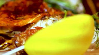 Otlar, limon, karabiber ile bir tabak kızarmış yengeç. Restoran yemek