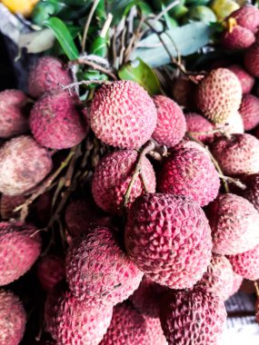 Olgun kırmızı litchi sepetleri içinde bir mağazanın önünde birlikte bir sürü var. Bunlar satışa çıkarıldı..