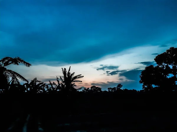 夕阳西下 印第安村庄的农田 蓝天的乌云 透过这些乌云 太阳光闪烁着 — 图库照片