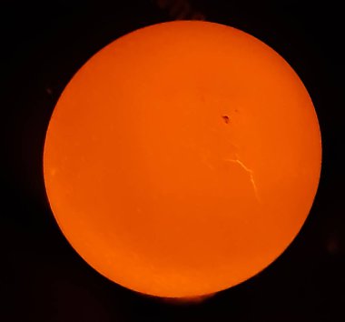 Bir yumurtanın arkasındaki ışık yanıyor ve yumurtanın parlak, siyah bir arka planı var. Bu, gecenin karanlığının bir resmi..