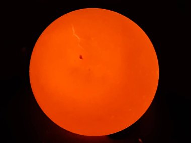 Bir yumurtanın arkasındaki ışık yanıyor ve yumurtanın parlak, siyah bir arka planı var. Bu, gecenin karanlığının bir resmi..