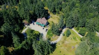 Yeşil ladin ormanının ortasındaki yalnız evin üzerinden uç. Kanada 'da ücra bir yer. Parlak güneşli bir gün.