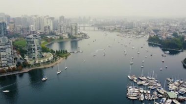 Vancouver 'daki False Creek' in havadan görünüşü demirli yatlar ve sisli şehir merkezi.