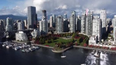 Vancouver şehir merkezinin hava manzarası ve kırmızı ve yeşil ağaçlı güzel bir park.