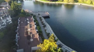 Güneşli bir günde nehir kıyısında koşucular ve motorcularla hava manzarası