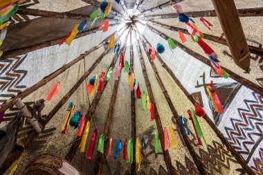 Wigwam içinde çok renkli kurdeleler ve püsküllerle süslenmiş.