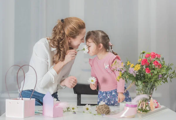 Mutlu anne ve kız tatil için buket yapıyorlar. Çiçeklerin aile işi. Anne ve kızı. Çiçekçi 