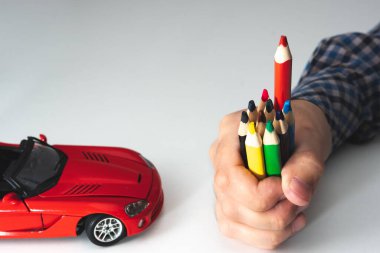 caring car service concept. car painting, auto color selection. a man holding colored pencils clipart