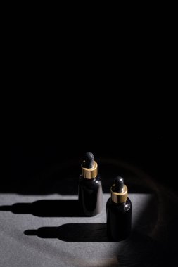 Siyah pippete şişesi arka planda.