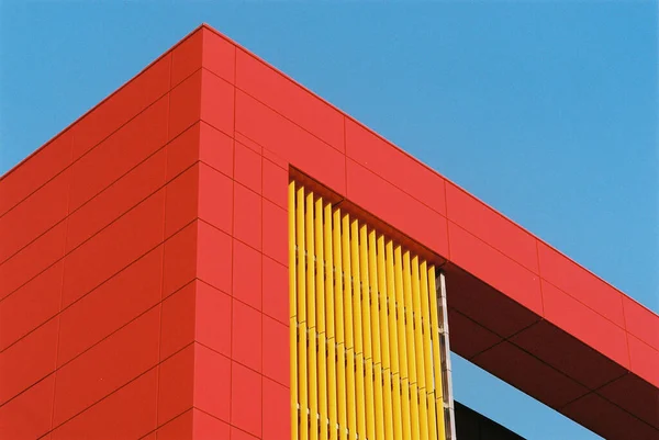 Koyu mavi arka planda kırmızı ve sarı parçaları olan güzel renkli minimalist bina manzarası. Minimalist dairenizin arka planı ya da web sitenizin güzel arka planı olabilir..