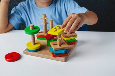 Çocukların tahta oyuncağı. Beynin interhemisferik gelişimi için bir tahta. Çocukların elleri, yakın plan. Çocuk gelişimi gecikmesi. Konuşma terapisti için ahşap labirent. Çocuk için Montessori Oyunları 