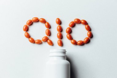 Beyaz arka planda Koenzim Q10 vitamini. Yaşlanmayı önlemek için. İlaçlar ve ilaçlar.