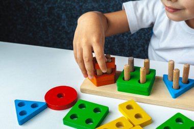 Çocuk montessori tahta oyuncağı. Çocuk bir tasnif makinesi topluyor. Çocuklar için eğitici mantık oyuncakları. Çocukların elleri, yakın plan. Çocuk Gelişimi için Montessori Oyunları