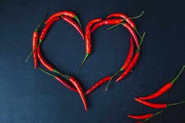 Siyah arka planda acı kırmızı biber. Biber kalp.