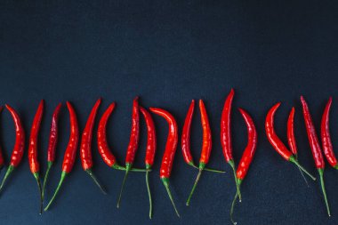 Kırmızı biber siyah arka planda yatar. Geleneksel Asya yemekleri. Tayland baharatları.